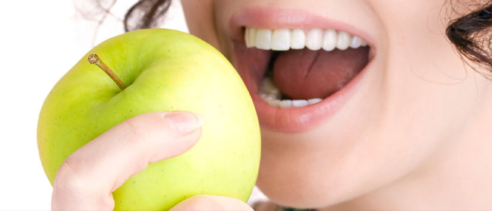 Femme souriant mangeant une pomme